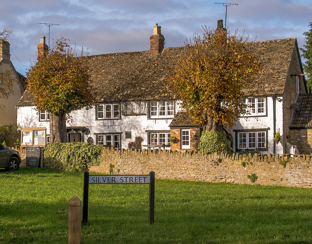 Stone cottages and autumn trees on Silver Street, Kington Langley